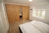 Schlafzimmer mit Doppelbett und großem Schrank